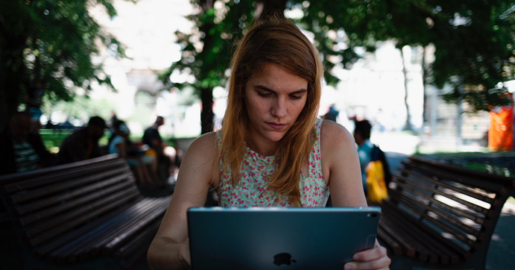 Woman uses iPad outdoors
